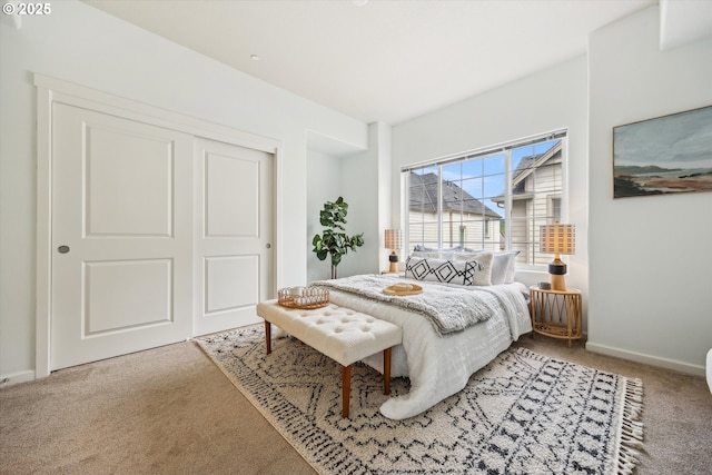 carpeted bedroom featuring a closet and baseboards