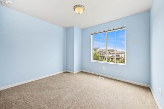 carpeted empty room featuring baseboards