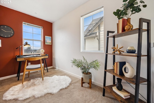 carpeted office space featuring plenty of natural light and baseboards