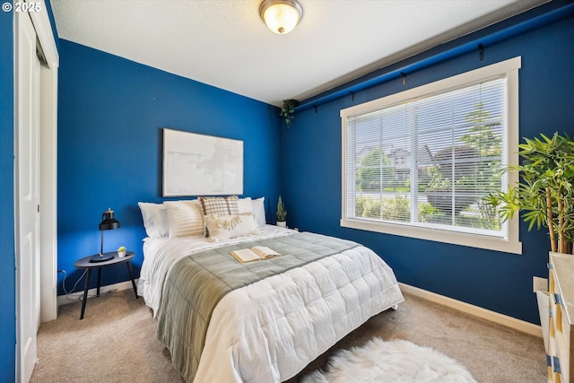 carpeted bedroom with multiple windows and baseboards
