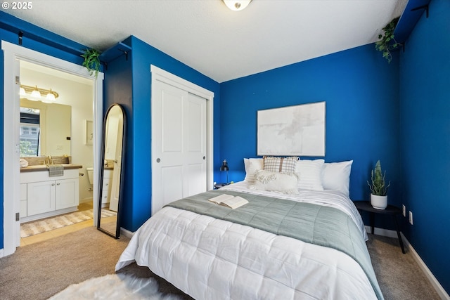 bedroom featuring carpet flooring, a closet, baseboards, and connected bathroom