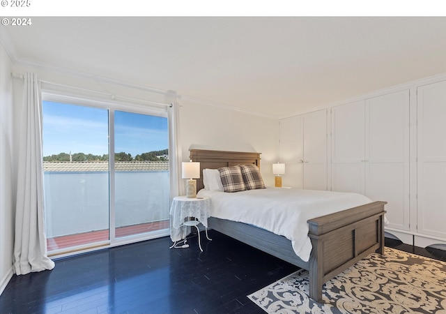 bedroom featuring crown molding, dark wood-type flooring, and access to exterior