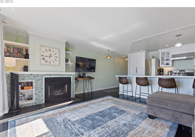 living room featuring ornamental molding and a tile fireplace