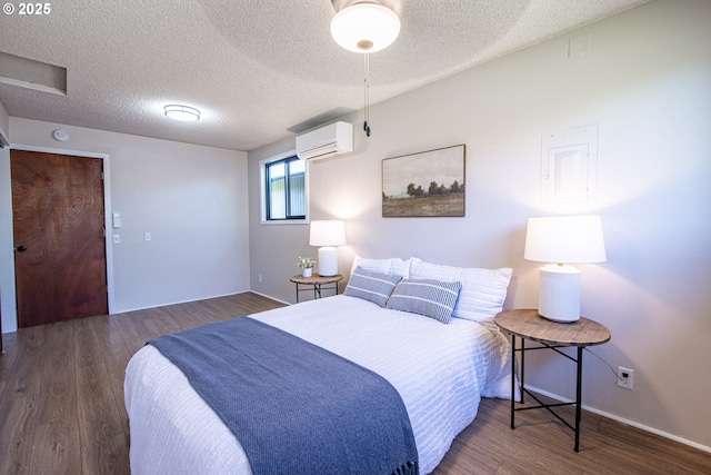 288 51st St, Springfield, OR 97478 - bedroom featuring a wall mounted air conditioner, a textured ceiling, baseboards, and wood finished floors
