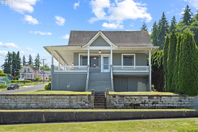 406 W C St, Rainier, OR 97048 - view of front of house featuring stairway, a porch, and a shingled roof