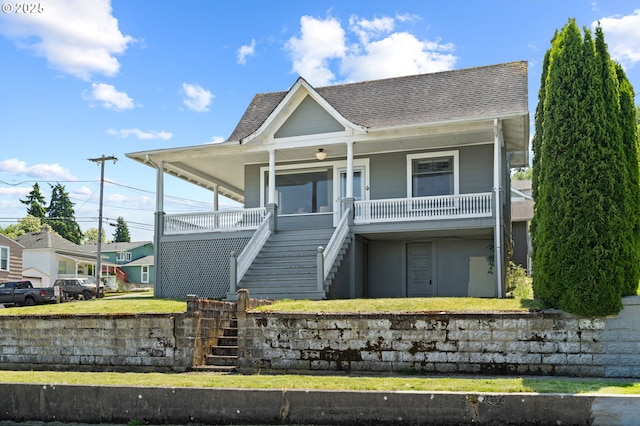 406 W C St, Rainier, OR 97048 - view of front facade with stairway, a shingled roof, a porch, and a front yard