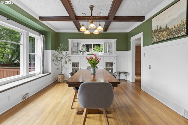 2006 SE 41st Ave, Portland, OR 97214 - dining space featuring a chandelier, coffered ceiling, healthy amount of natural light, a fireplace, and wood finished floors