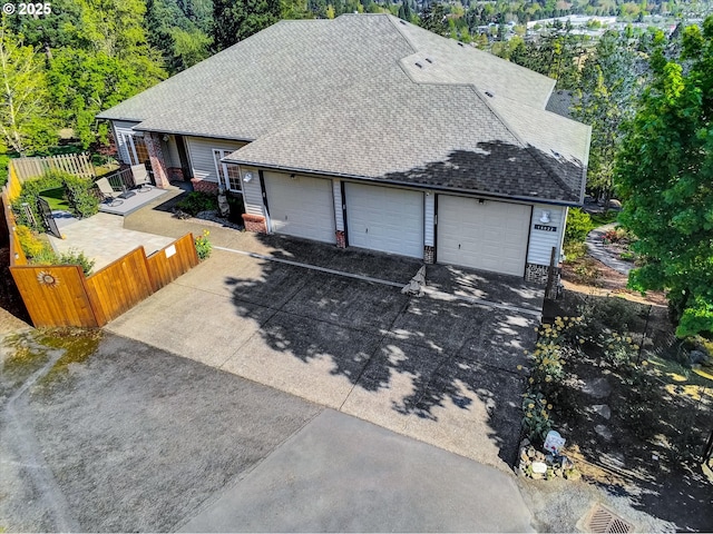 view of front of home with fence, a shingled roof, and brick siding