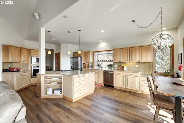 kitchen featuring a sink, decorative backsplash, wood finished floors, and stainless steel appliances