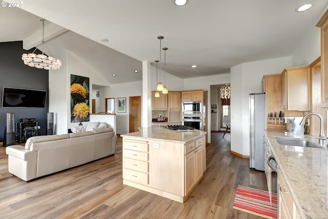 kitchen with light wood-type flooring, light brown cabinetry, a sink, open floor plan, and appliances with stainless steel finishes