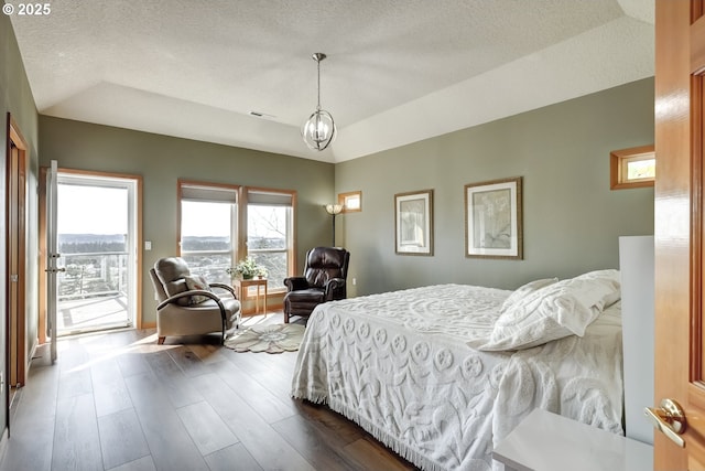 bedroom with access to exterior, a chandelier, lofted ceiling, a textured ceiling, and dark wood-style flooring