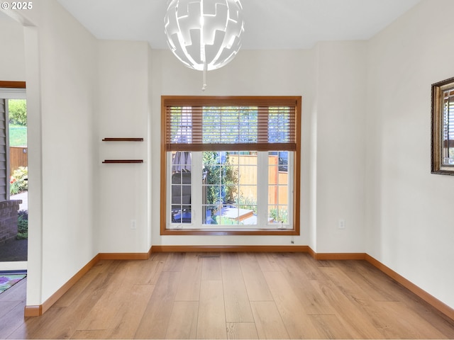 spare room featuring light wood-style floors and plenty of natural light