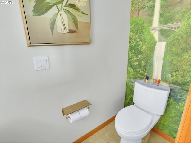 bathroom with toilet, baseboards, and tile patterned flooring
