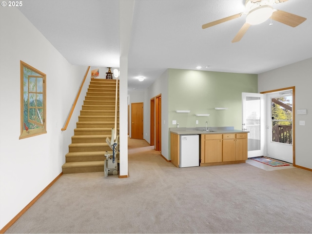 unfurnished living room featuring wet bar, a sink, baseboards, light carpet, and stairs