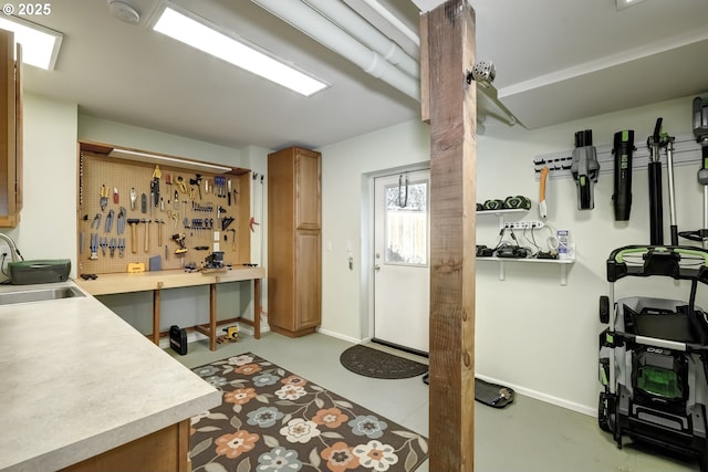 interior space featuring a workshop area, baseboards, and a sink