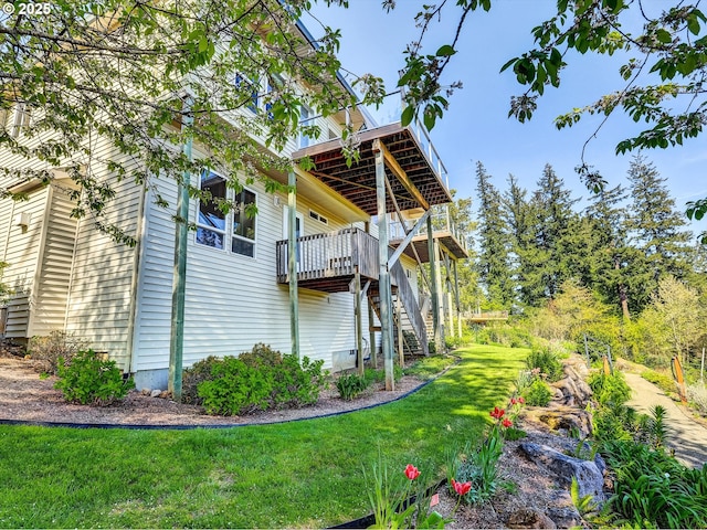view of side of home with stairs, a lawn, and a wooden deck