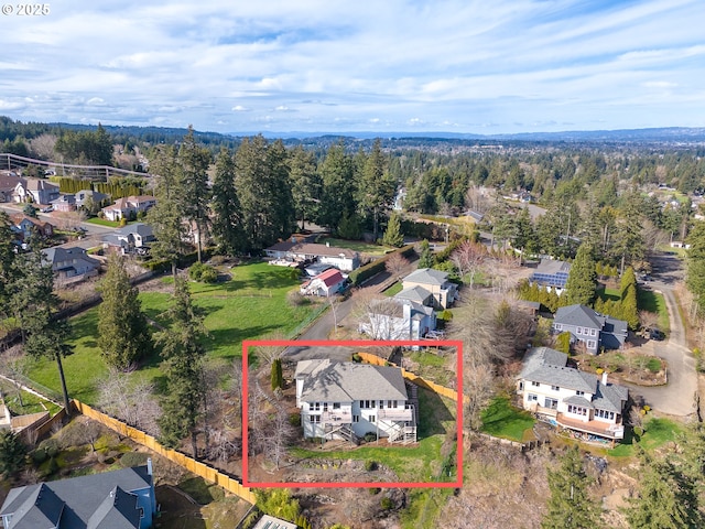 bird's eye view featuring a residential view and a wooded view