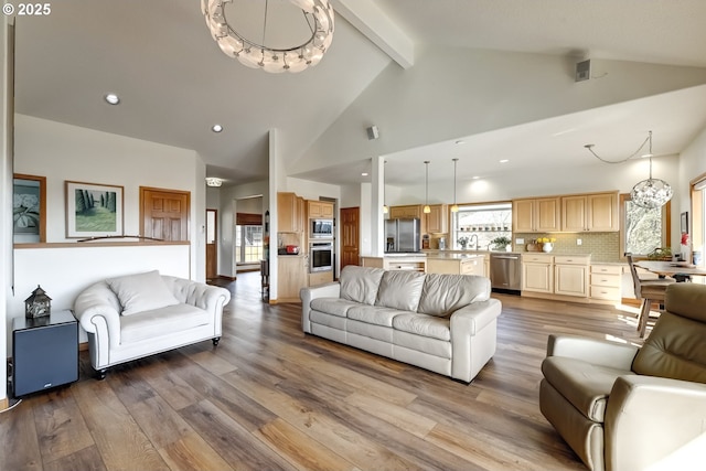 living room with wood finished floors, visible vents, high vaulted ceiling, beamed ceiling, and a chandelier