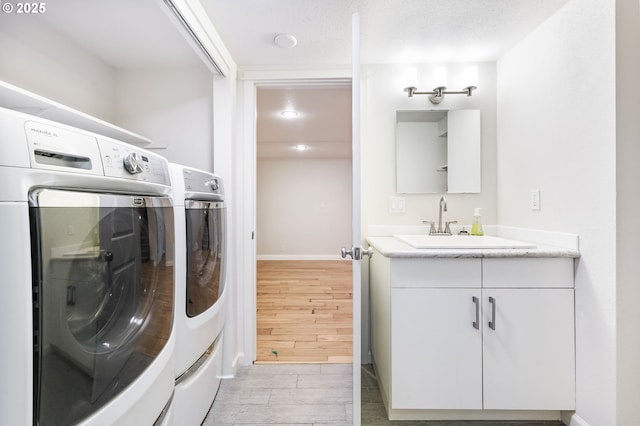 5200 SW Scholls Ferry Rd, Portland, OR 97225 - laundry area with laundry area, washing machine and dryer, baseboards, wood finish floors, and a sink