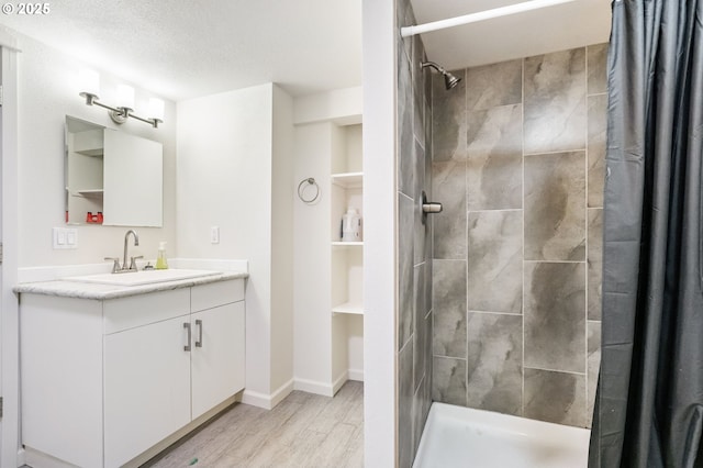 5200 SW Scholls Ferry Rd, Portland, OR 97225 - full bathroom with vanity, baseboards, wood finished floors, and tiled shower