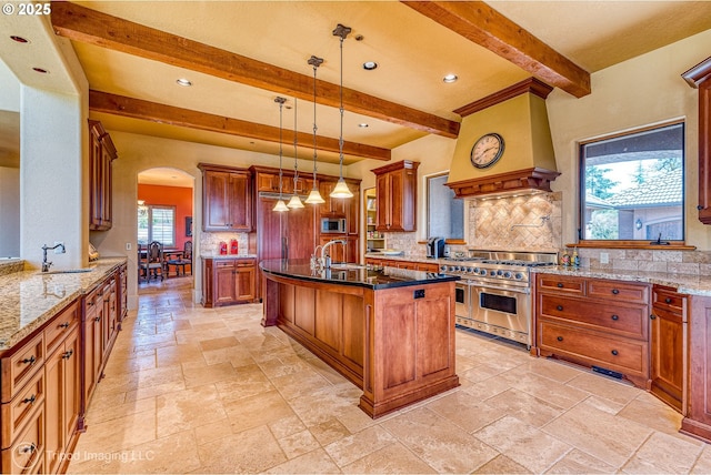 kitchen featuring sink, tasteful backsplash, pendant lighting, appliances with stainless steel finishes, and custom exhaust hood