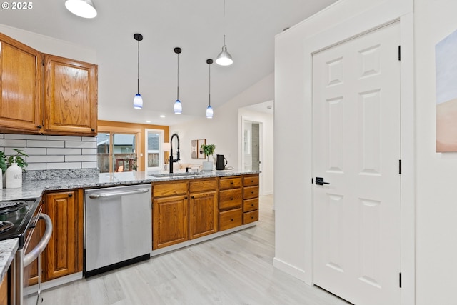 kitchen featuring a sink, light stone counters, appliances with stainless steel finishes, and brown cabinetry