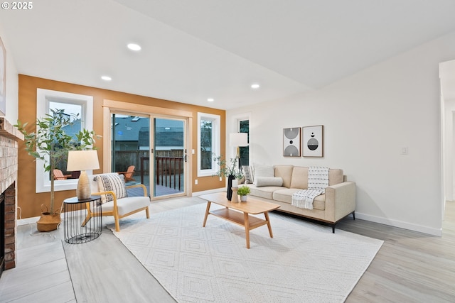 living area with recessed lighting, a fireplace, light wood-style floors, and baseboards