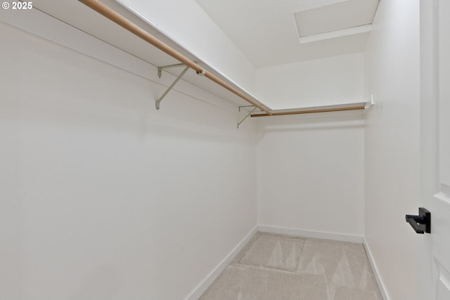 spacious closet featuring light colored carpet and attic access