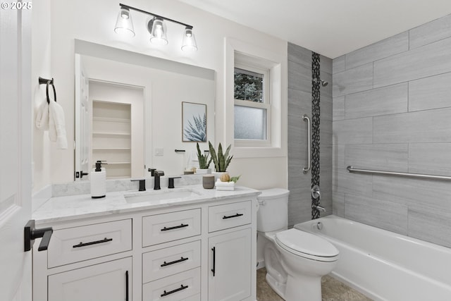 bathroom featuring toilet, vanity, and  shower combination