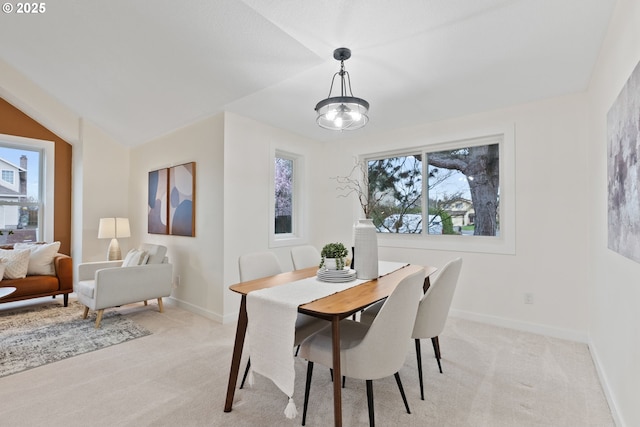 dining space featuring baseboards and light carpet