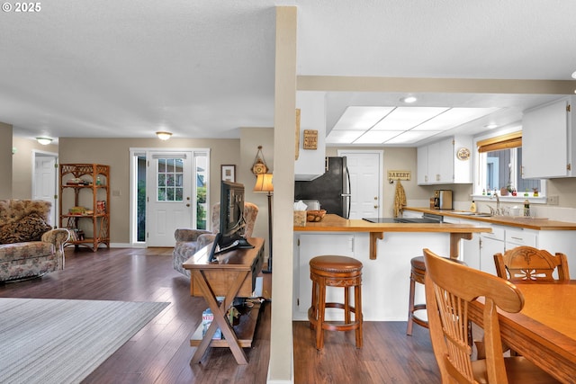 1588 20th St, Florence, OR 97439 - kitchen featuring freestanding refrigerator, open floor plan, white cabinets, a peninsula, and recessed lighting