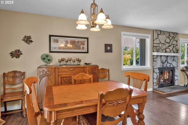 1588 20th St, Florence, OR 97439 - dining room featuring a chandelier, wood finished floors, and a stone fireplace