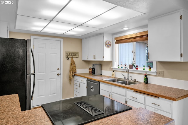 1588 20th St, Florence, OR 97439 - kitchen featuring freestanding refrigerator, stainless steel dishwasher, stovetop with downdraft, and white cabinetry