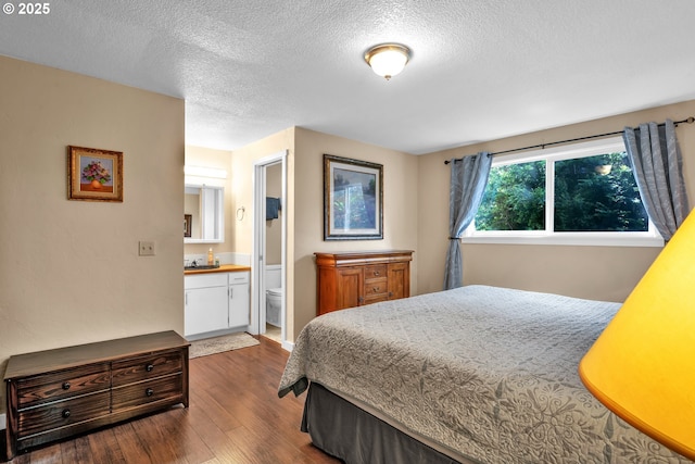 1588 20th St, Florence, OR 97439 - bedroom featuring wood finished floors, a textured ceiling, and ensuite bathroom