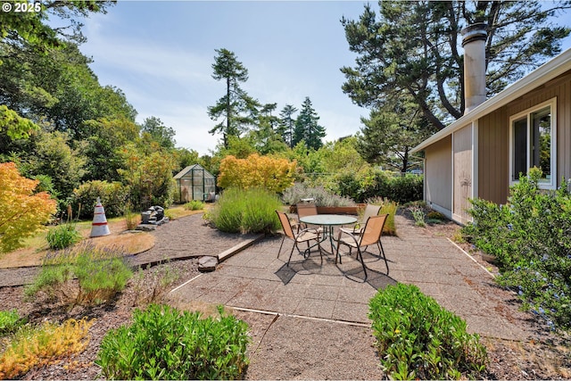 1588 20th St, Florence, OR 97439 - view of patio / terrace featuring a greenhouse, outdoor dining area, and an outdoor structure