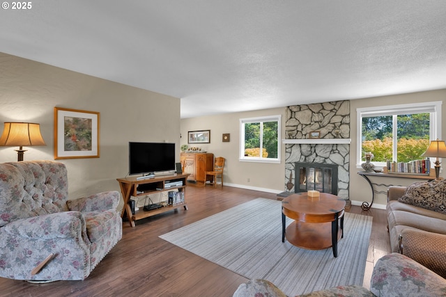 1588 20th St, Florence, OR 97439 - living area featuring wood finished floors, a stone fireplace, and a textured ceiling