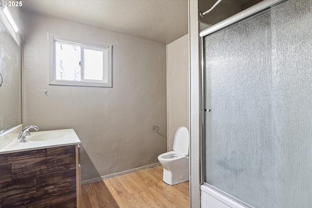 254 Humphrey Addition Rd, Glendale, OR 97442 - full bathroom with wood finished floors, a shower with door, toilet, and vanity