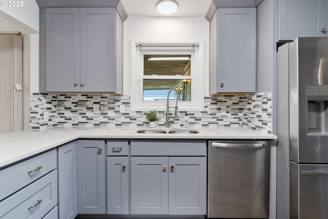 10525 SE Mitchell St, Portland, OR 97266 - kitchen with stainless steel appliances, a sink, light countertops, decorative backsplash, and gray cabinetry