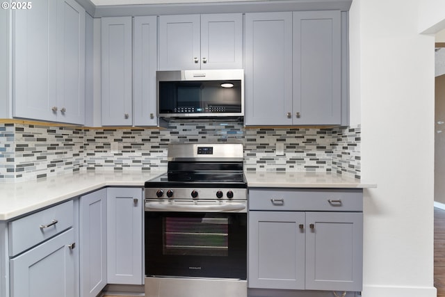 10525 SE Mitchell St, Portland, OR 97266 - kitchen with appliances with stainless steel finishes, gray cabinets, light countertops, and decorative backsplash