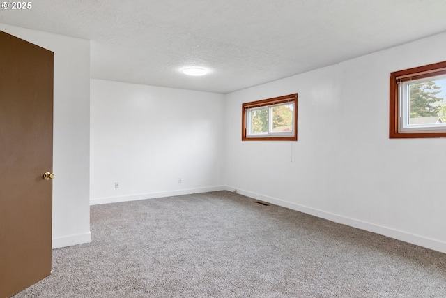 10525 SE Mitchell St, Portland, OR 97266 - carpeted empty room featuring healthy amount of natural light, baseboards, and a textured ceiling