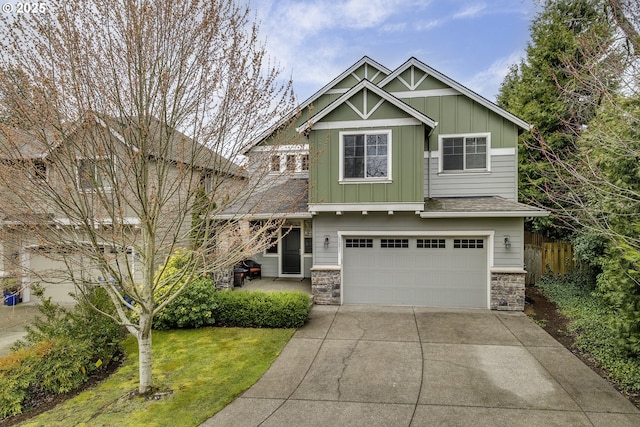 craftsman inspired home with board and batten siding, fence, concrete driveway, a garage, and stone siding