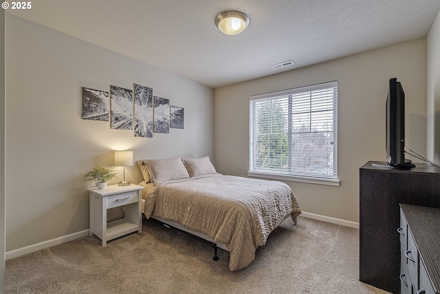 bedroom with light carpet, visible vents, a textured ceiling, and baseboards