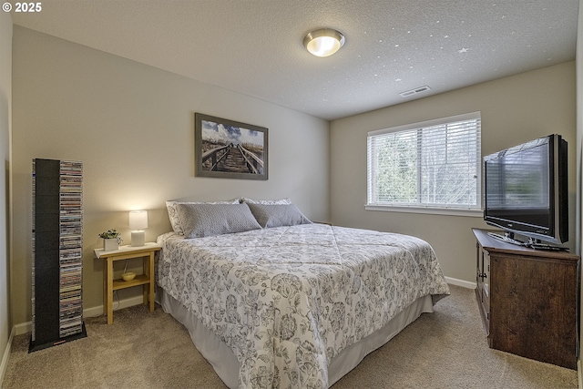 bedroom featuring carpet flooring, a textured ceiling, baseboards, and visible vents