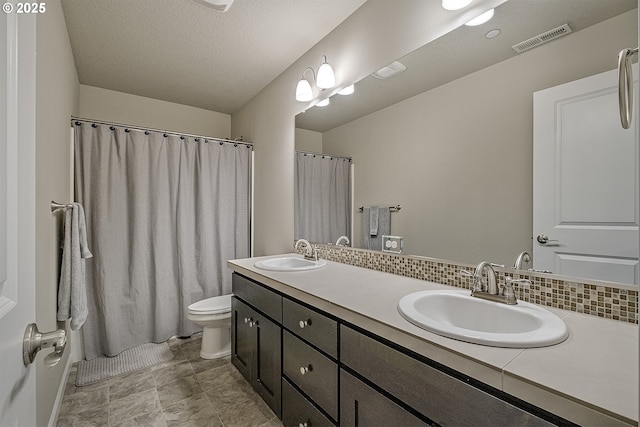 bathroom with a sink, visible vents, toilet, and backsplash