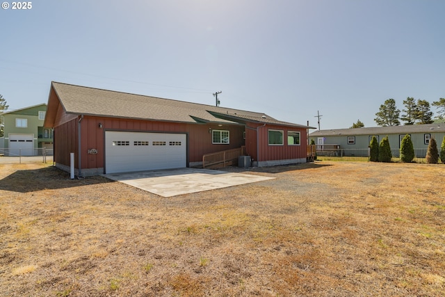 125 S 12th St, Lakeside, OR 97449 - view of front of home featuring an attached garage, board and batten siding, central air condition unit, driveway, and roof with shingles