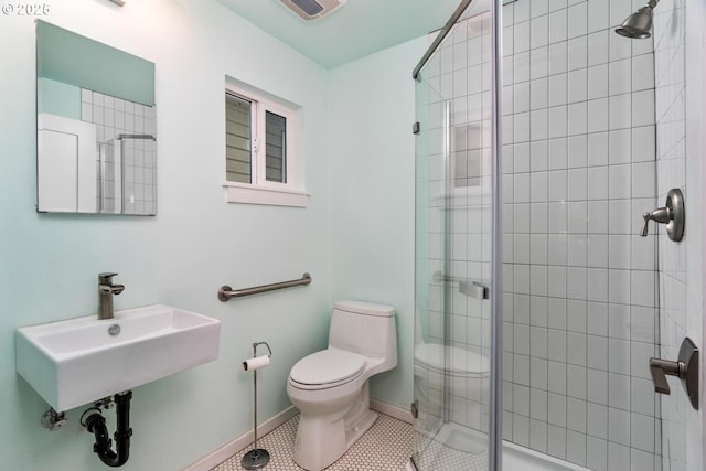 full bathroom featuring toilet, a shower stall, baseboards, a sink, and tile patterned floors