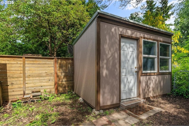 view of outbuilding with fence and an outdoor structure
