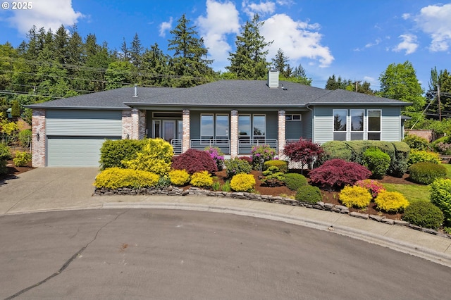 view of front of house with a chimney, an attached garage, concrete driveway, and a shingled roof