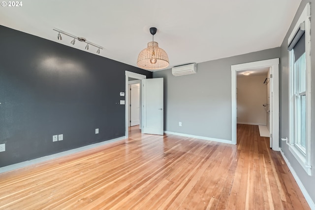 9116 N Willamette Blvd, Portland, OR 97203 - unfurnished room featuring a wall mounted AC, light wood-type flooring, and track lighting