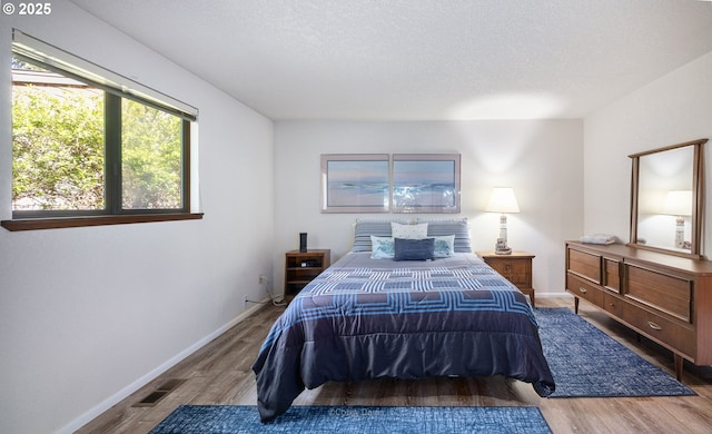 bedroom with wood finished floors and baseboards